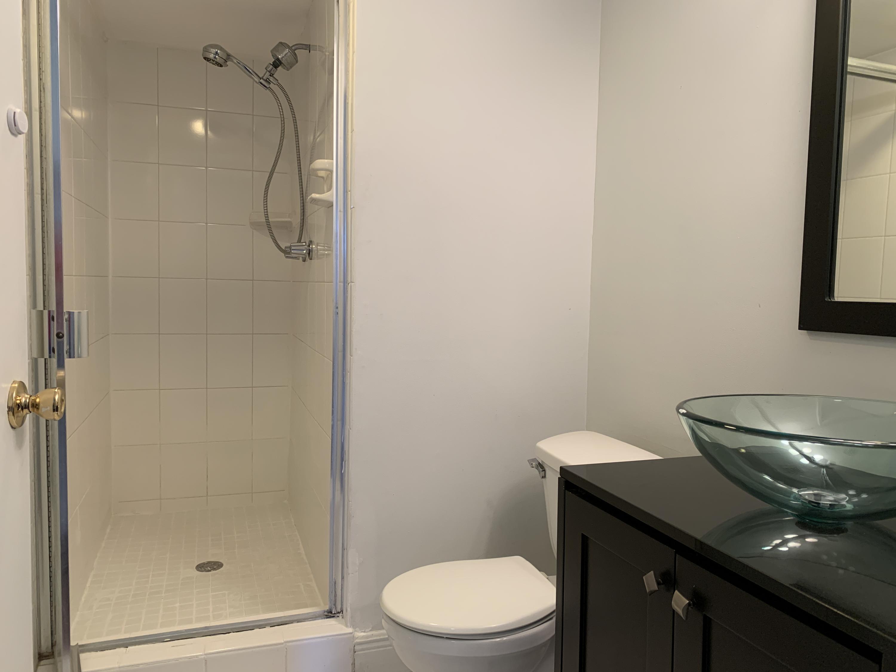 9370 Southwest 8th Street, Unit 202 Boca Raton, FL 33428 - Photo 29 of 46 a bathroom with a sink a toilet and shower