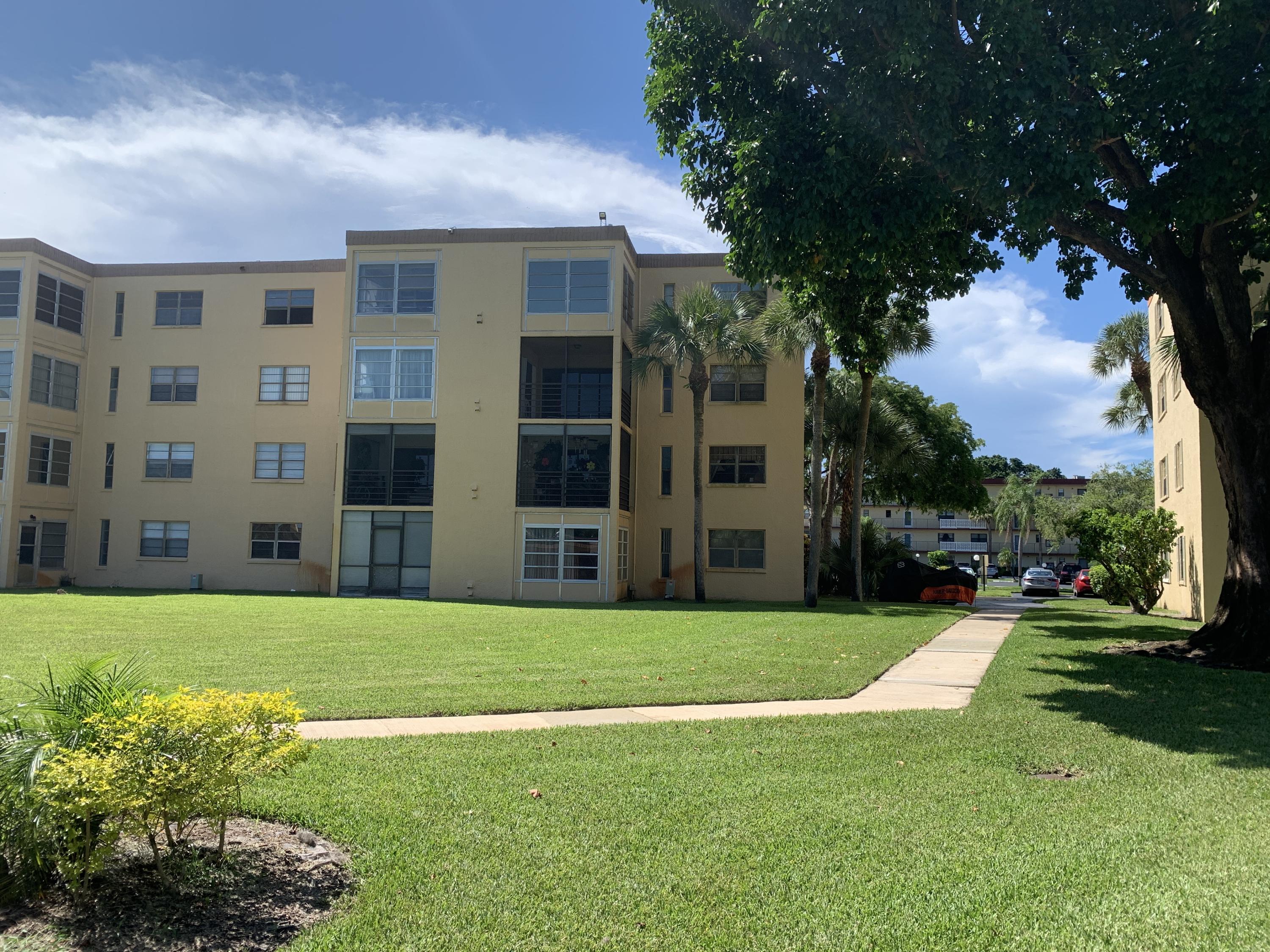 9370 Southwest 8th Street, Unit 202 Boca Raton, FL 33428 - Photo 35 of 46 a view of a apartment with a big yard and potted plants