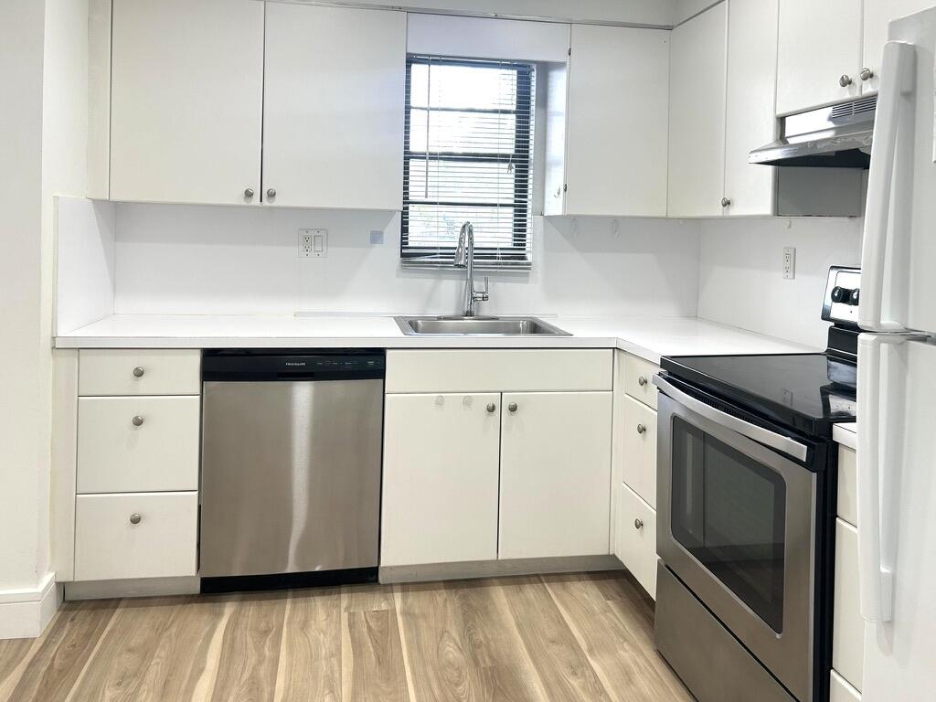 9370 Southwest 8th Street, Unit 202 Boca Raton, FL 33428 - Photo 4 of 46 a kitchen with granite countertop white cabinets stainless steel appliances and sink