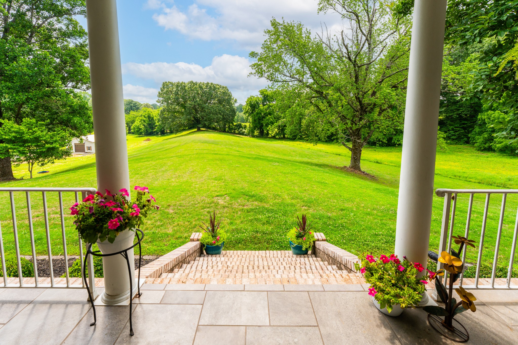 1015 Kelly Road Dyersburg, TN 38024 - Photo 8 of 41 a view of a garden with a bench in front of a house