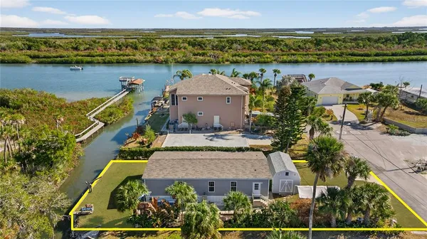 an aerial view of a house with a garden and lake view