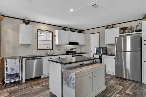 a kitchen with a refrigerator a sink and cabinets
