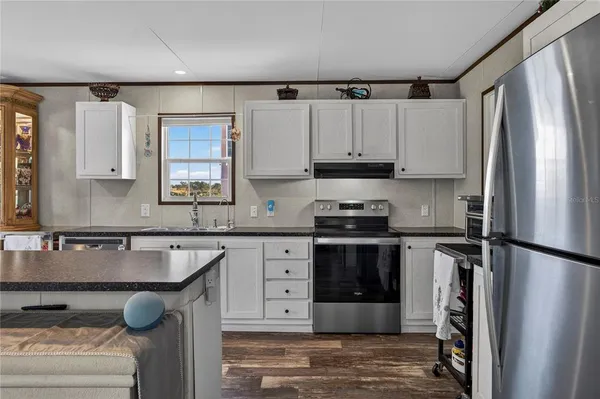 a kitchen with a refrigerator sink and white cabinets