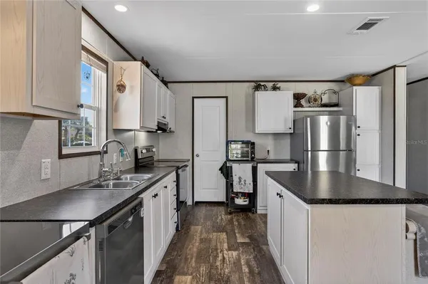 a kitchen with stainless steel appliances granite countertop a sink stove and refrigerator