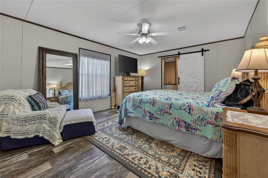 185 Coleman Street Edgewater, FL 32141 - Photo 20 of 47 a bedroom with a large bed and a chandelier