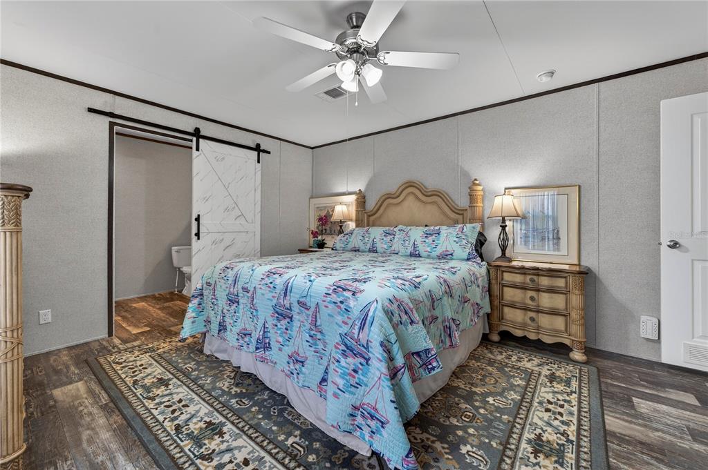 185 Coleman Street Edgewater, FL 32141 - Photo 22 of 47 a bedroom with a bed and a chandelier