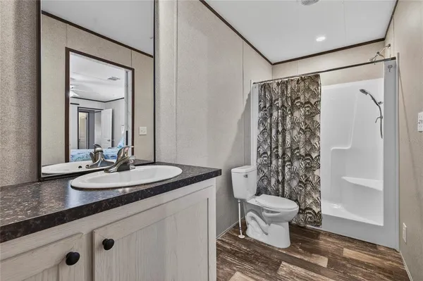 a bathroom with a granite countertop sink toilet and shower