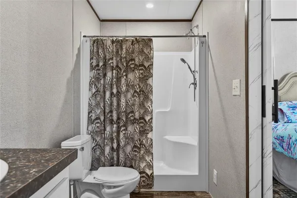 a bathroom with a granite countertop shower and a toilet