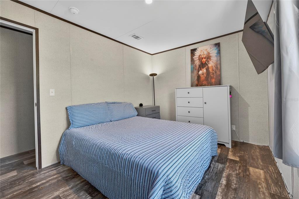 185 Coleman Street Edgewater, FL 32141 - Photo 28 of 47 a bedroom with a bed and a painting on the wall