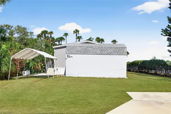 a front view of a house with a garden and trees