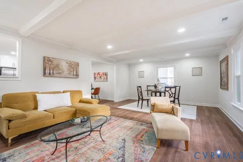 a living room with furniture and wooden floor