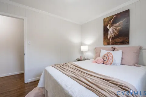a bedroom with a bed and a painting on the wall
