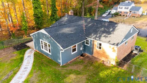 a aerial view of a house with swimming pool and large trees