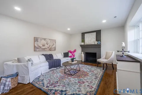 a living room with furniture a fireplace and wall paintings