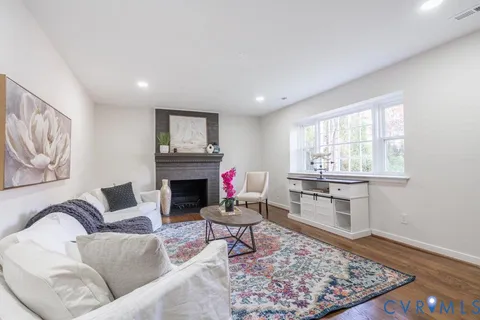 a living room with furniture a rug and a fireplace