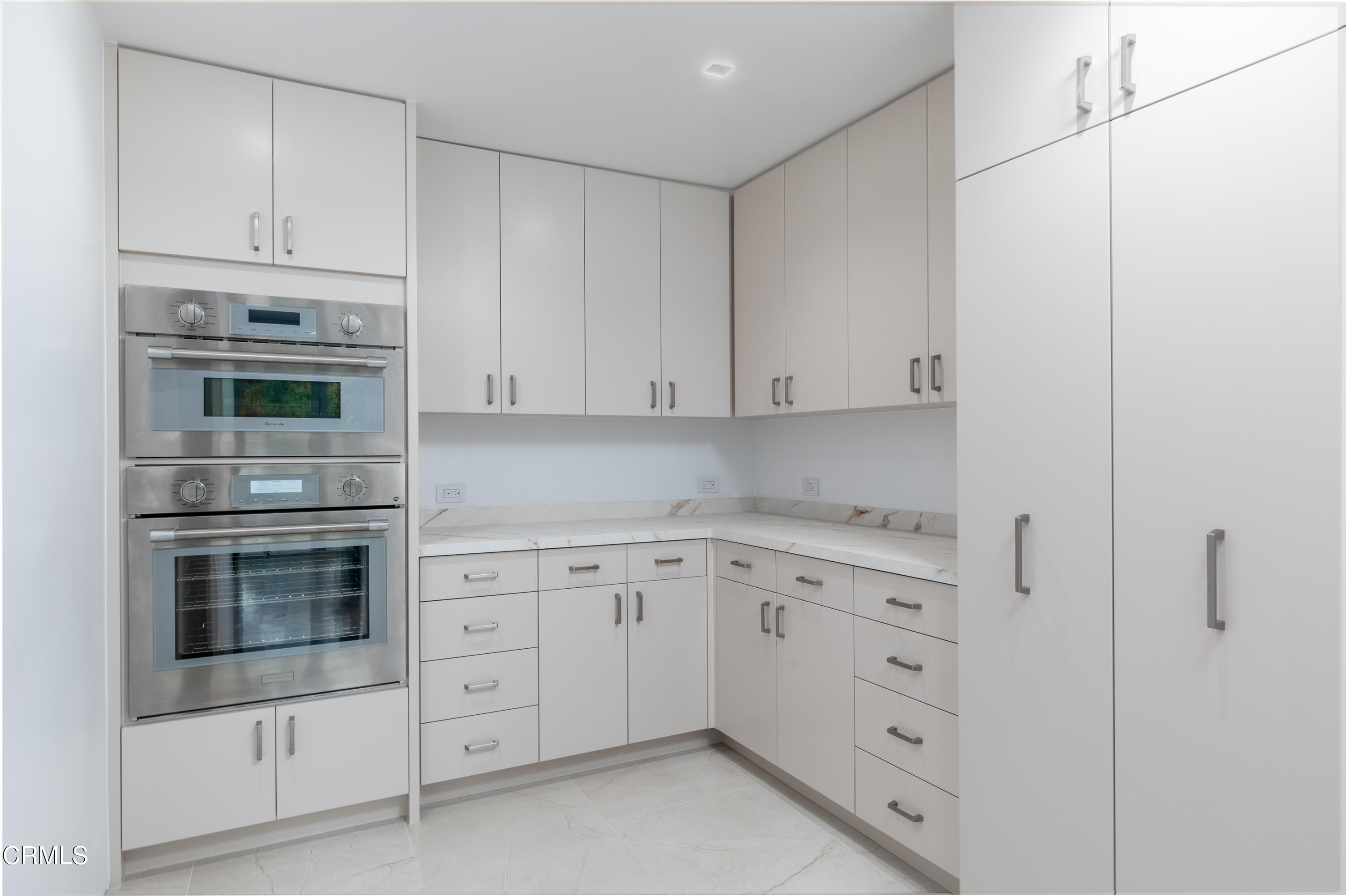 800 Canon Drive Pasadena, CA 91106 - Photo 23 of 49 a kitchen with white cabinets and stainless steel appliances