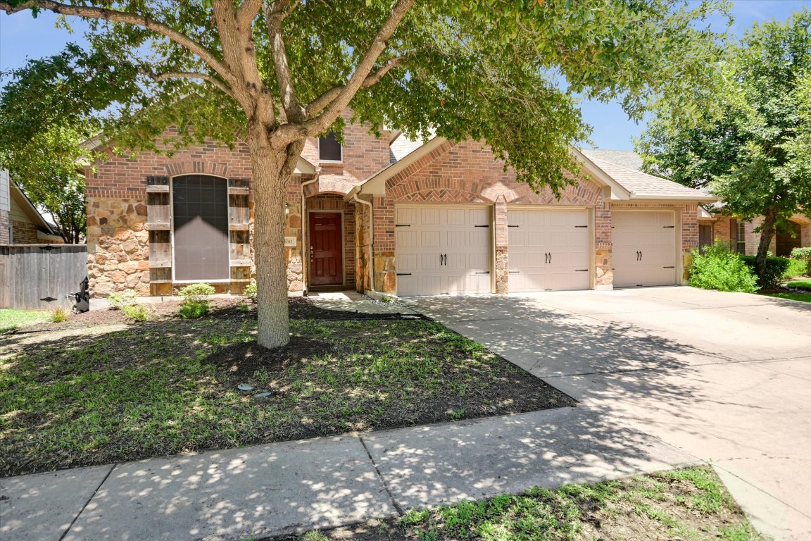 a front view of a house with a yard and trees