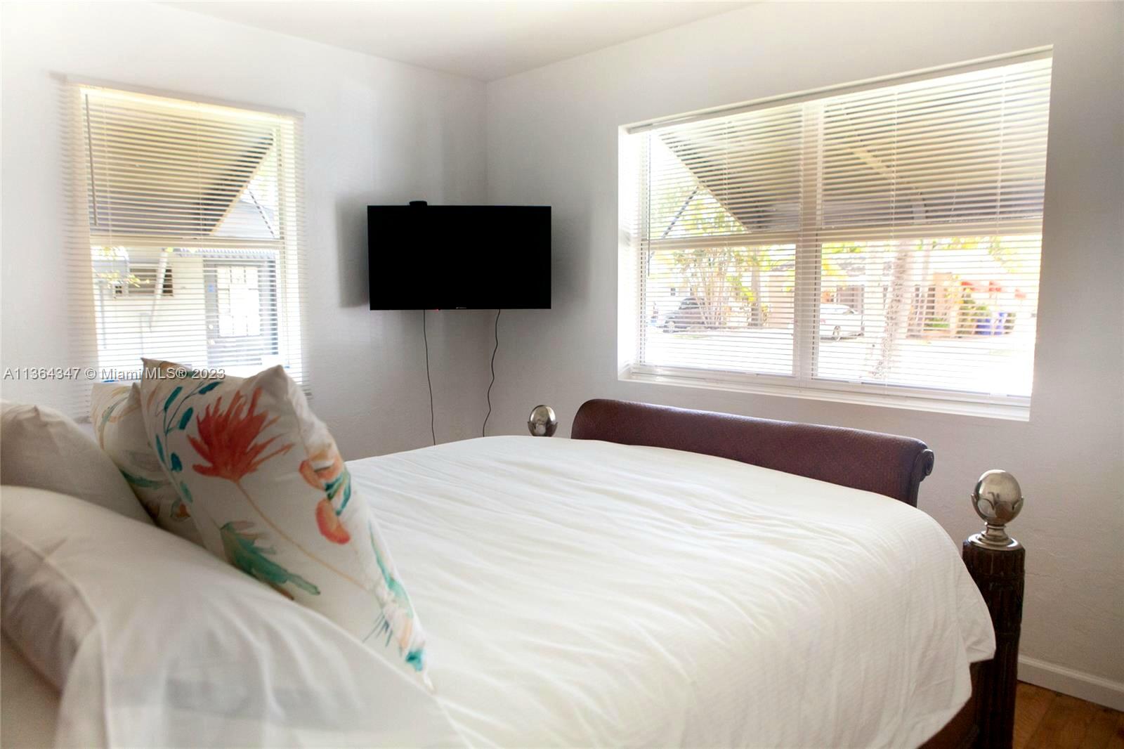 1821 Harding Street, Unit 12 Hollywood, FL 33020 - Photo 13 of 14 a bedroom with a bed and a flat tv screen on the dresser
