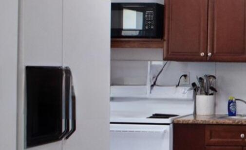1821 Harding Street, Unit 12 Hollywood, FL 33020 - Photo 8 of 14 a kitchen with a refrigerator and cabinets