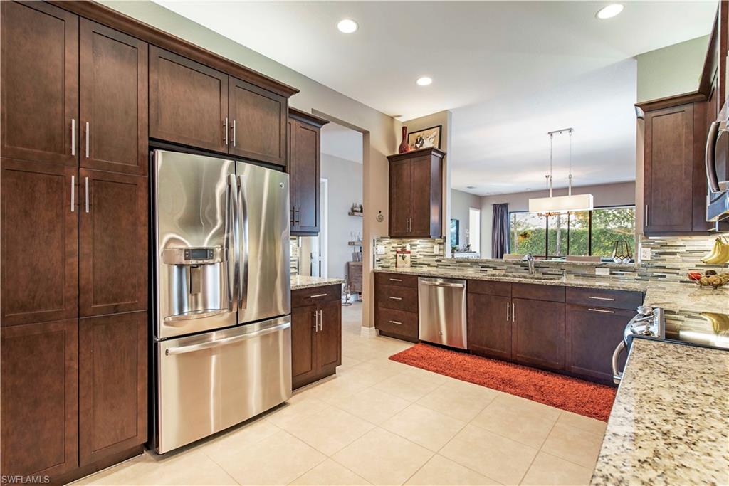 a kitchen with stainless steel appliances granite countertop a refrigerator stove and oven