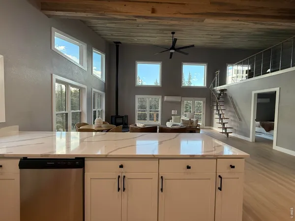 a kitchen with stainless steel appliances granite countertop a sink stove refrigerator and cabinets