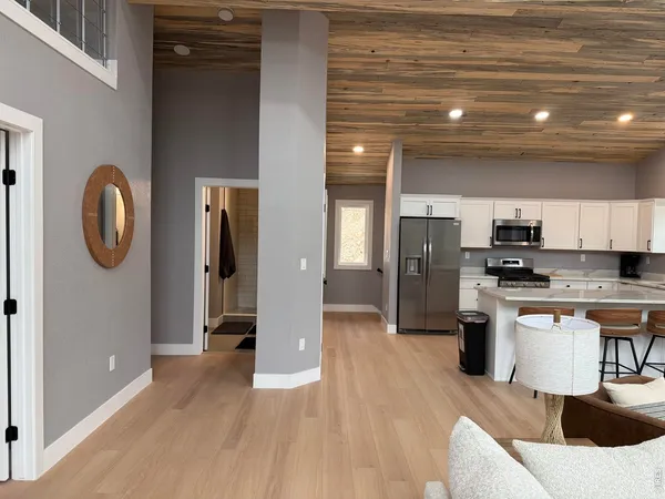 a living room with stainless steel appliances kitchen island granite countertop furniture a kitchen island a sink a stove and a refrigerator