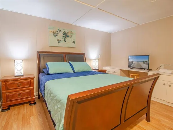 a bedroom with a bed and wooden floor