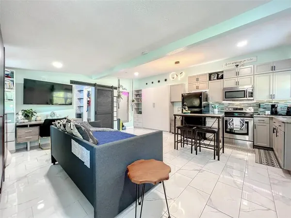 a kitchen with stainless steel appliances kitchen island granite countertop a stove a sink a dining table and chairs
