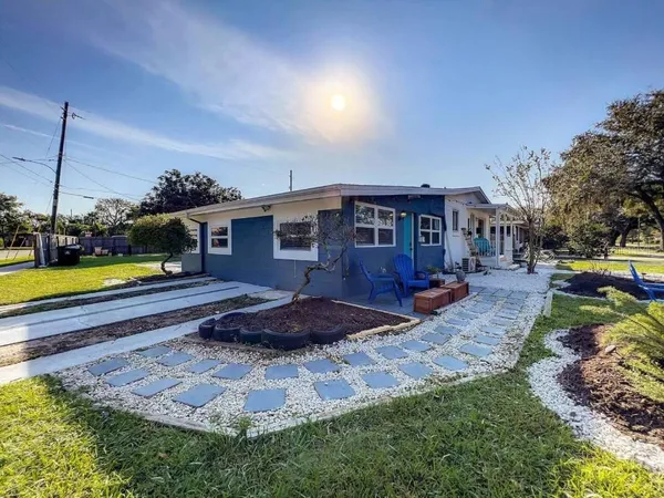 a view of a house with a yard and sitting area