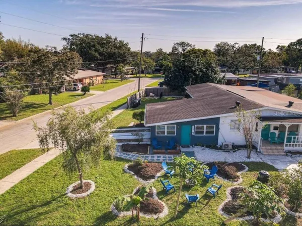 a view of a house with swimming pool lawn chairs and a yard