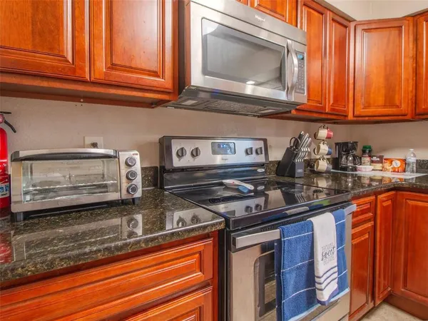 a kitchen with stainless steel appliances granite countertop a sink stove and microwave