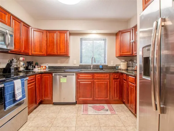 a kitchen with stainless steel appliances granite countertop a refrigerator stove top oven and sink