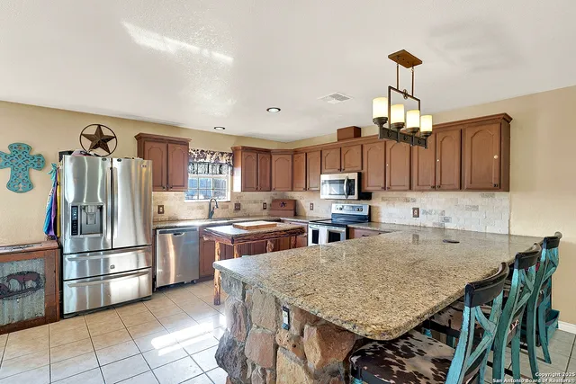 a kitchen with stainless steel appliances granite countertop a stove refrigerator and cabinets