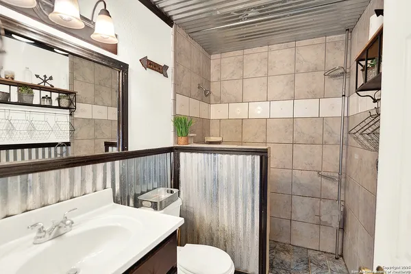 a bathroom with a sink a toilet and shower