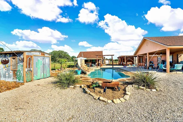 a view of a house with swimming pool and sitting area