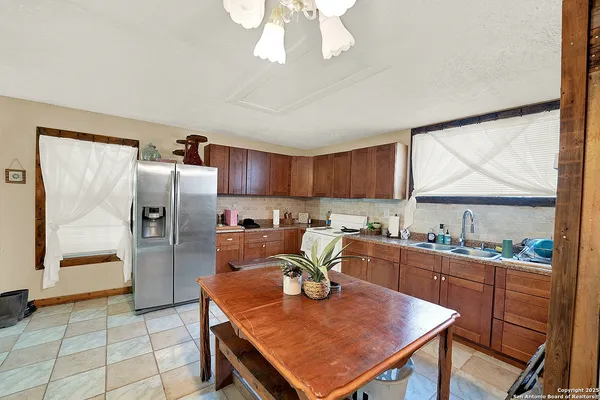 a kitchen with stainless steel appliances granite countertop a stove refrigerator sink and cabinets
