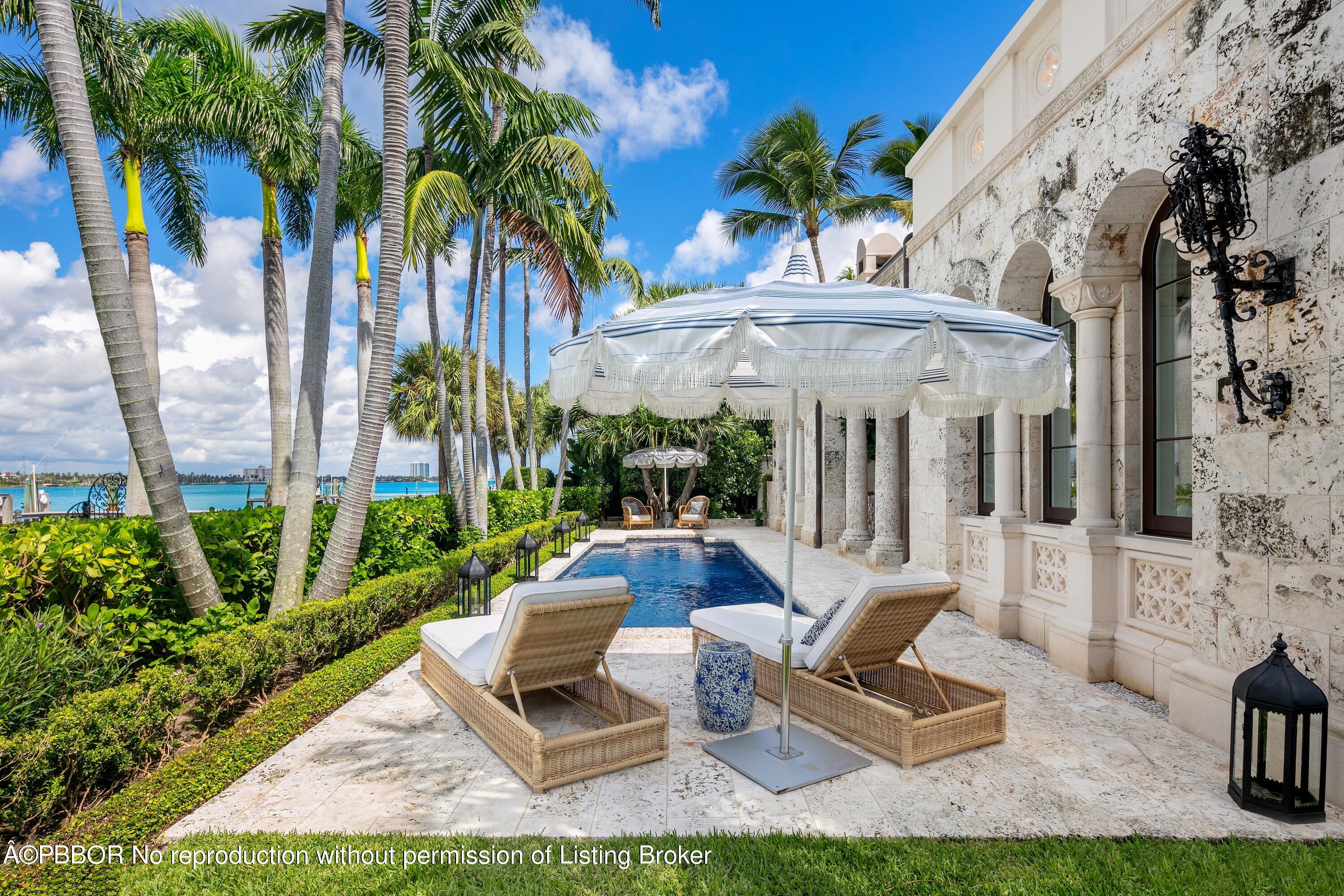 313 Dunbar Road Palm Beach, FL 33480 - Photo 54 of 73 a view of a patio with table and chairs potted plants and palm trees