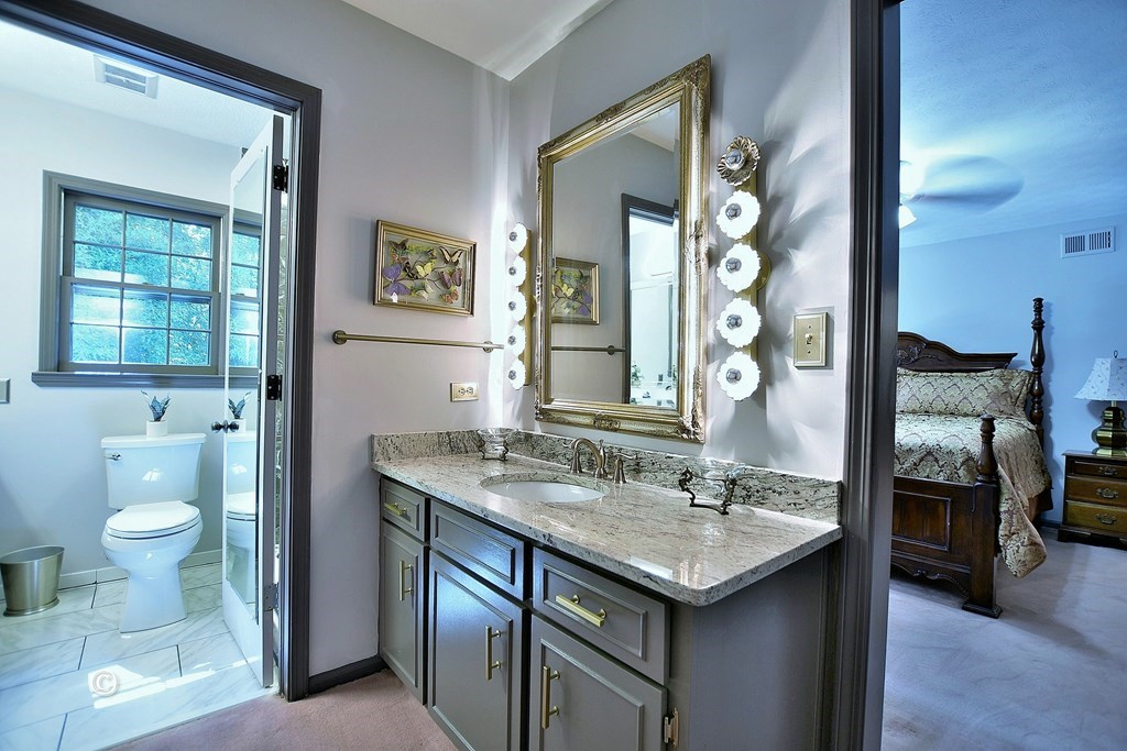 1237 Smith Road Fortson, GA 31808 - Photo 17 of 31 a bathroom with a granite countertop sink a toilet and a mirror