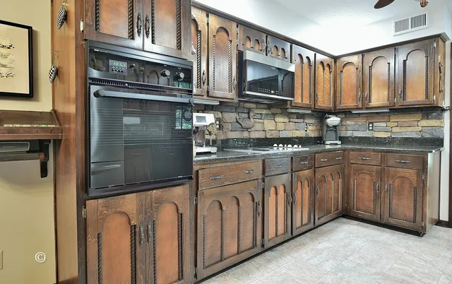 a kitchen with stainless steel appliances granite countertop a refrigerator a stove and a sink