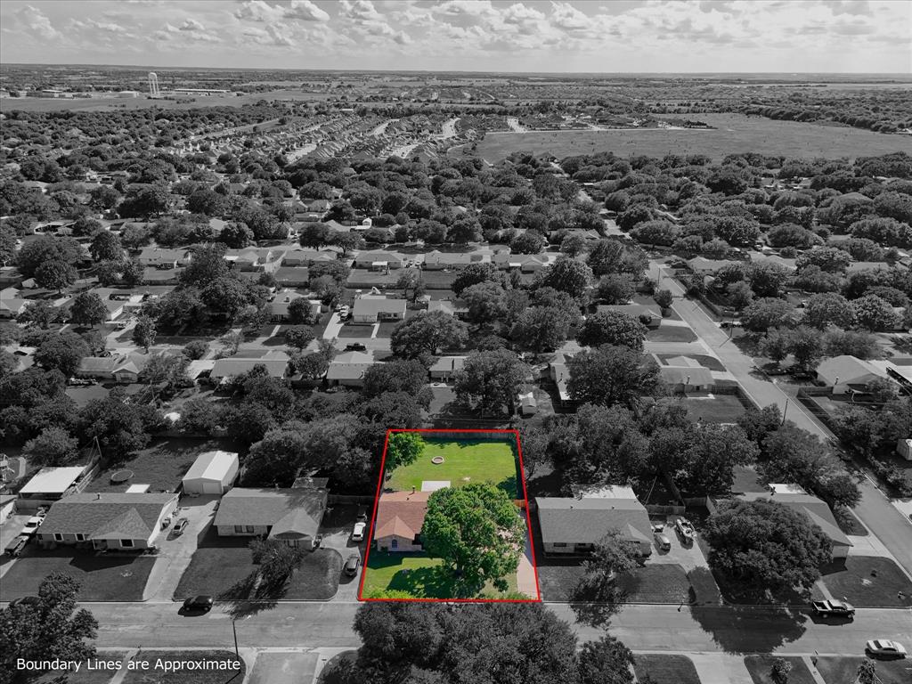 141 Travis Lane Hewitt, TX 76643 - Photo 4 of 31 Aerial view of the property featuring a pitched roof, mature trees, and an expansive lawn