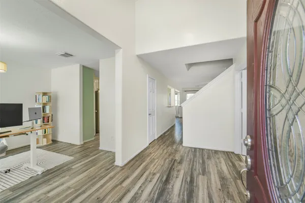 a kitchen with stainless steel appliances a refrigerator a sink dishwasher a stove and white cabinets with wooden floor
