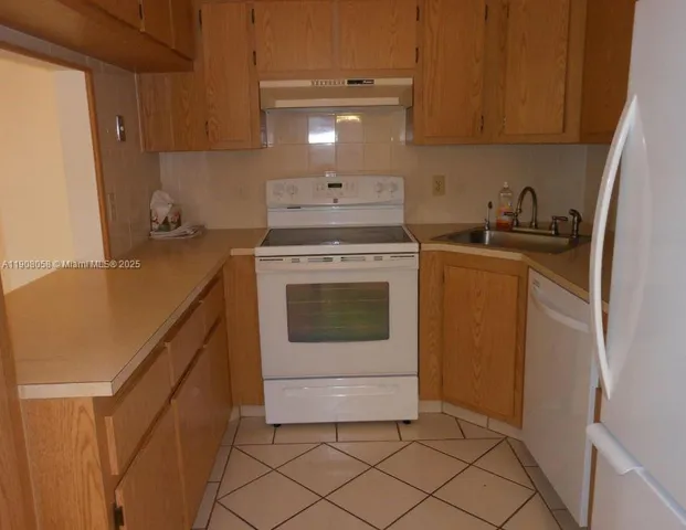 a kitchen with a stove sink and cabinets