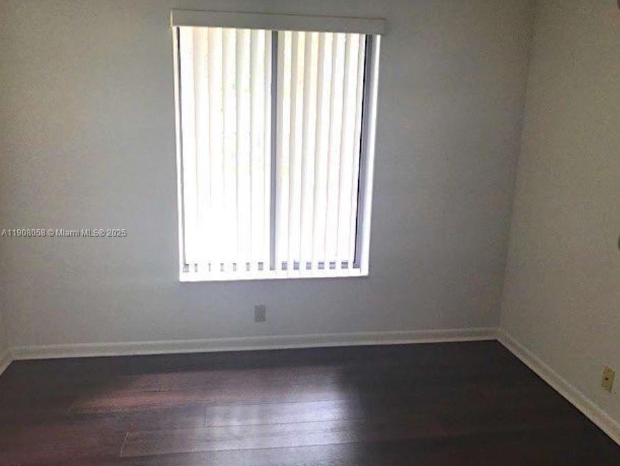 802 Sky Pine Way, Unit B2 Greenacres, FL 33415 - Photo 4 of 9 an empty room with wooden floor and windows