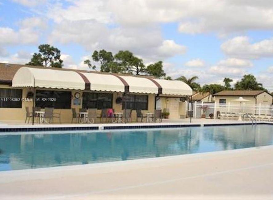 802 Sky Pine Way, Unit B2 Greenacres, FL 33415 - Photo 9 of 9 a view of a house with a yard and sitting area