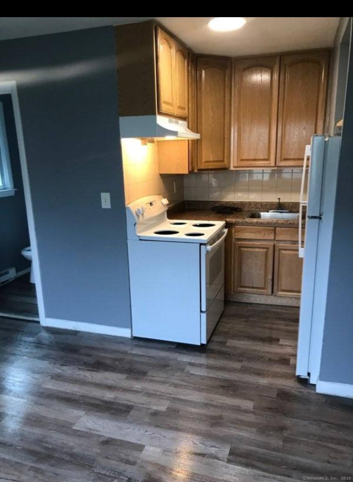 a kitchen with stainless steel appliances granite countertop a stove a sink and a refrigerator