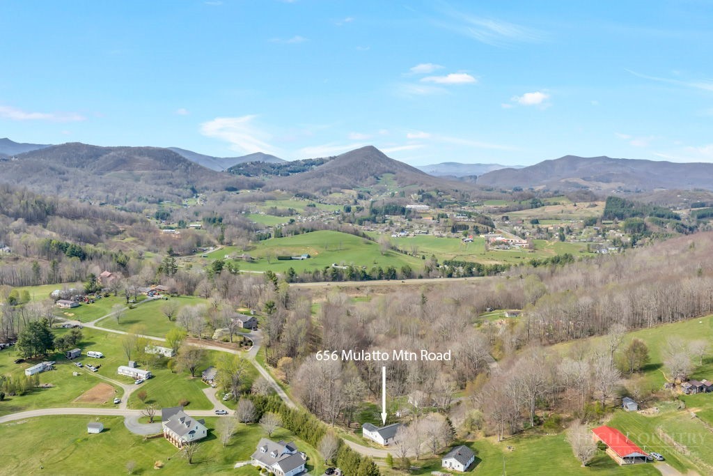 656 Mulatto Mountain Road West Jefferson, NC 28694 - Photo 35 of 35 a view of a lush green hillside and houses