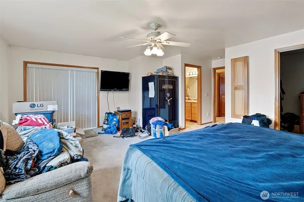 a bedroom with a bed and a flat tv screen on dresser