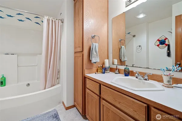 a bathroom with a tub sink and mirror