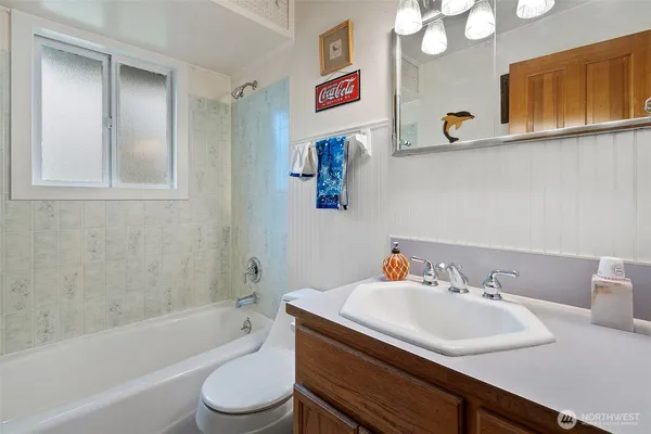 a bathroom with a sink vanity mirror and toilet