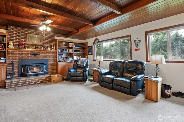 a living room with furniture a fireplace and a floor to ceiling window